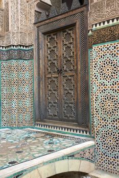 Ornate carving on the plastered walls and on the woodwork in the courtyard of the historic Madrasa Bou Inania in the ancient medina of Fes in Morocco