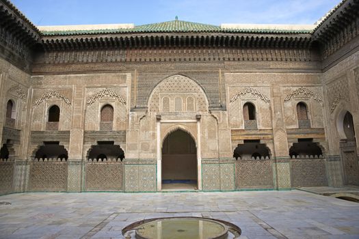 Ornate carving on the plastered walls and on the woodwork in the courtyard of the historic Madrasa Bou Inania in the ancient medina of Fes in Morocco