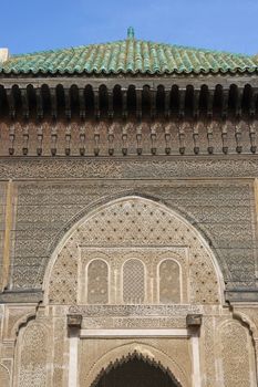 Ornate carving on the plastered walls and on the woodwork in the courtyard of the historic Madrasa Bou Inania in the ancient medina of Fes in Morocco