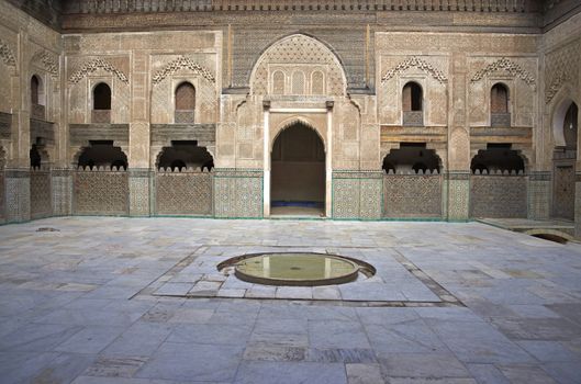Ornate carving on the plastered walls and on the woodwork in the courtyard of the historic Madrasa Bou Inania in the ancient medina of Fes in Morocco