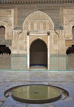 Ornate carving on the plastered walls and on the woodwork in the courtyard of the historic Madrasa Bou Inania in the ancient medina of Fes in Morocco