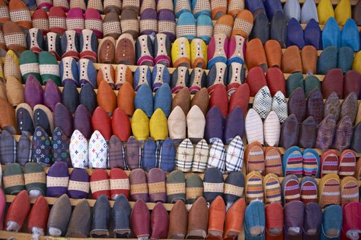 Colorful display of traditional leather slippers for sale in the souk of Fes in Morocco.