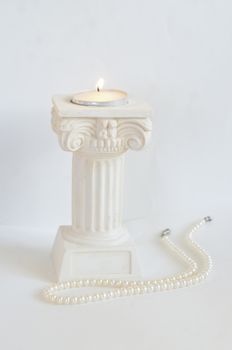 Burning white candle in antique style