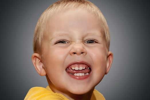 Face little boy on the gray background.