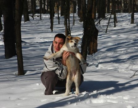 Puppie of Japanese dog Akita Inu,wth his owner,Belgrade,Serbia.First steps on the snow.