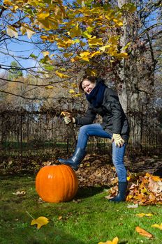smiling woman pose with large pumpkin in autumnal park yard