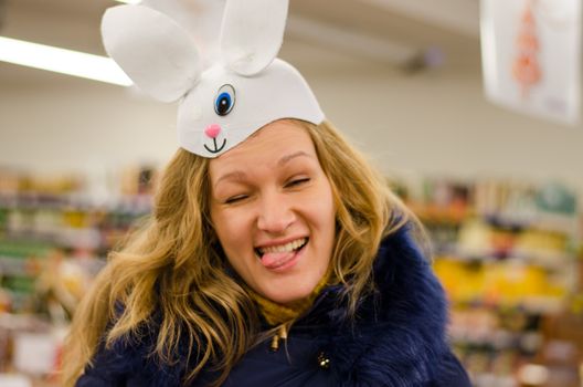 VILNIUS, LITHUANIA - DECEMBER 14: crazy cheerful young woman imitates oneeyed bunny mask image on December 14, 2013 in Vilnius, Lithuania.