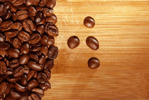 Bunch of fresh coffee beans on wooden table.