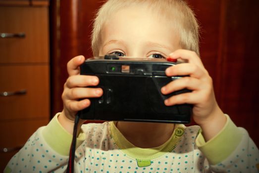 Young child with camera in hand.