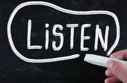 listen handwritten with chalk on a blackboard