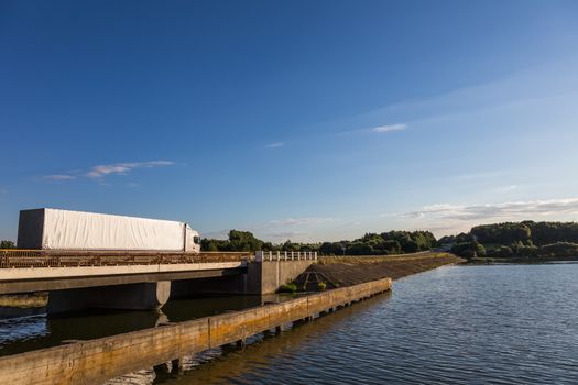 Truck delivery cargoes. Moving through lake on the bridge