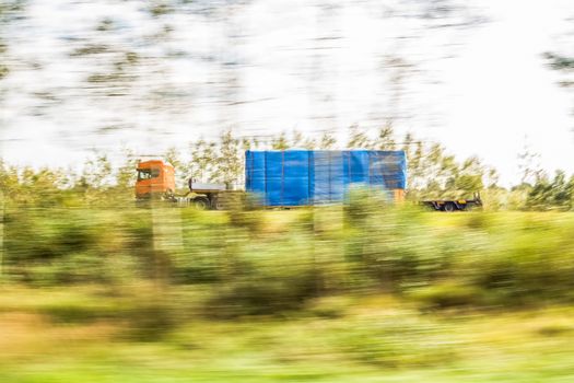 Truck delivery oversized cargo behind the trees