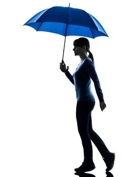 one caucasian woman holding umbrella in silhouette studio isolated on white background