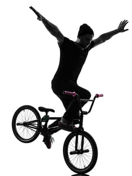 one caucasian man exercising bmx acrobatic figure in silhouette studio isolated on white background