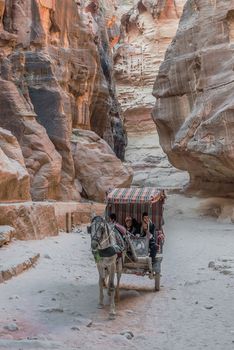 Petra, Jordan - May 11, 2013: people in horse cart at the Siq path in Nabatean Petra Jordan