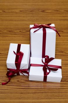 white gift box and red ribbin on wood background