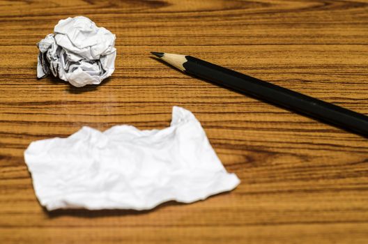 paper scrap and crumpled with pencil on wood background