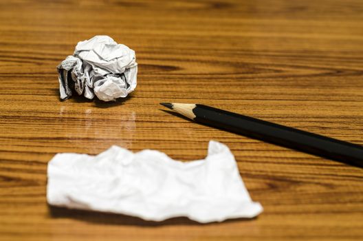 paper scrap and crumpled with pencil on wood background