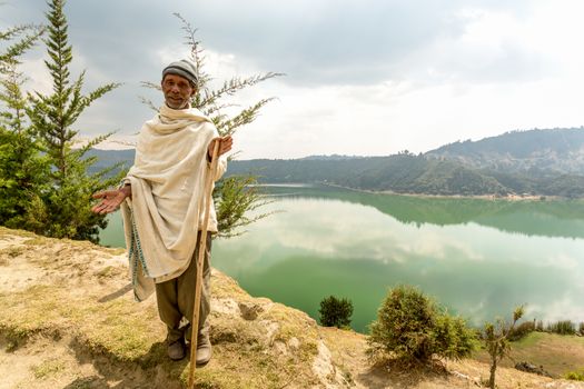 Wonchi, Ethiopia - February, 2014: An elderly resident of a village which promotes eco-tourism to improve the livelihood of the local community, greets tourists who come to visit the magnificent Wonchi Crater Lake, on 9 February, 2014, Wonchi, Ethiopia