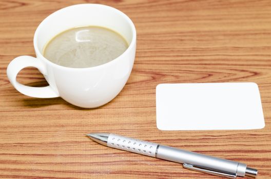 coffee cup and business card on wood background