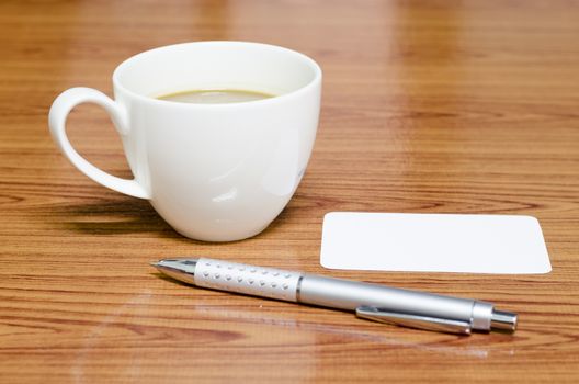 coffee cup and business card on wood background