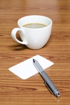 coffee cup and business card on wood background
