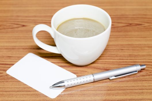 coffee cup and business card on wood background