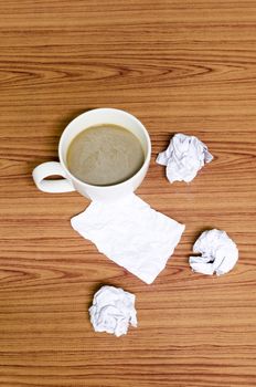coffe cup and crumpled for idea on wood background