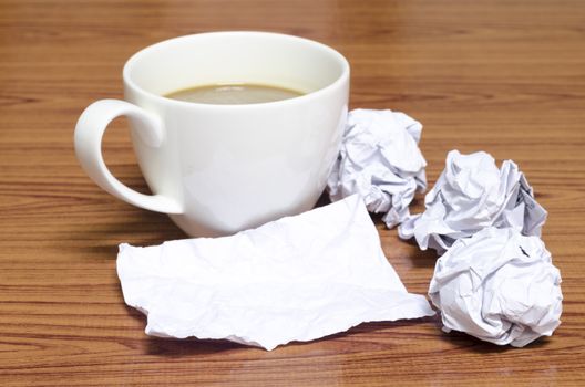 coffe cup and crumpled for idea on wood background