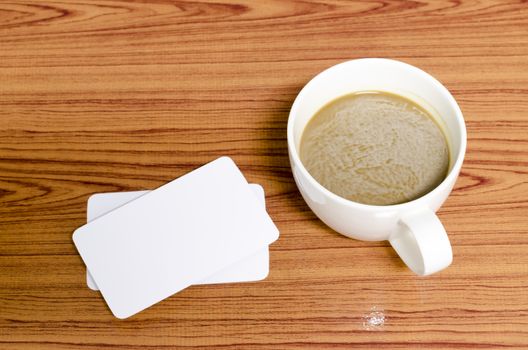 coffee cup and business card on wood background