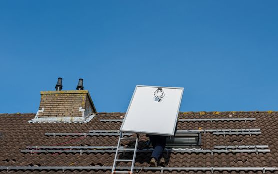 man climbing the ladder to the roof with solar panel