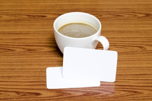 coffee cup and business card on wood background