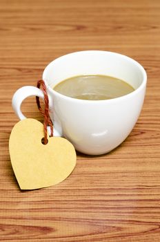 coffee cup with heart tag on wood background