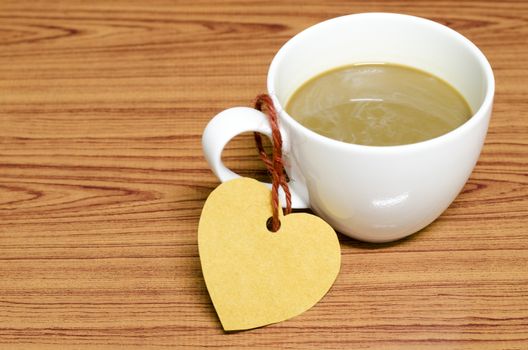 coffee cup with heart tag on wood background