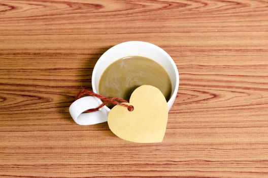 coffee cup with heart tag on wood background