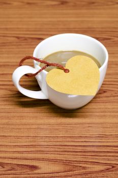 coffee cup with heart tag on wood background