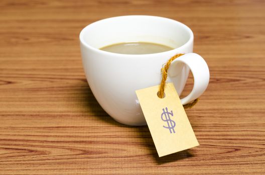 coffee cup with price tag on wood background