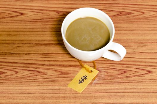 coffee cup with price tag on wood background