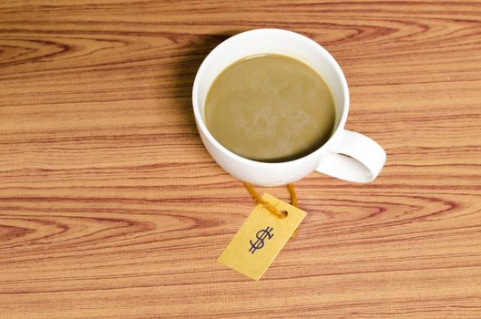 coffee cup with price tag on wood background