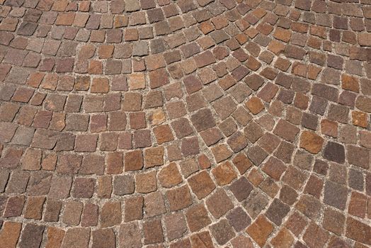 Geometric floor with multi colored blocks of porphyry (sanpietrini), typical urban paving in Italy