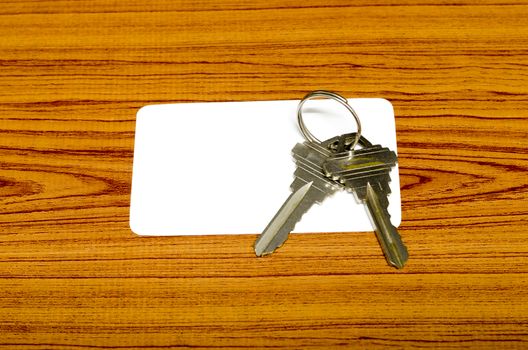 business card and keys on wood background