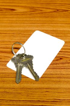 business card and keys on wood background