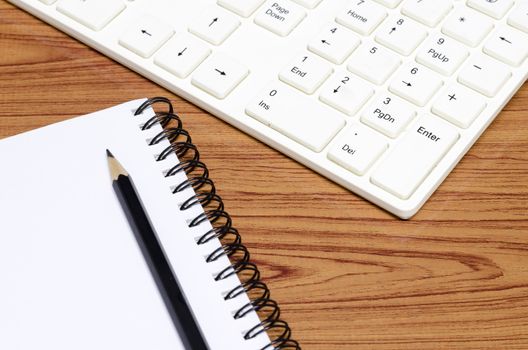 keyboard computer with notebook and pencil