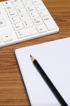 keyboard computer with notebook and pencil