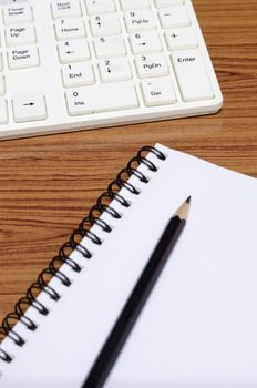 keyboard computer with notebook and pencil