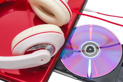 Portable computer with DVD compact disc and red white headphones isolated