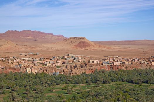 Traditional Berber village and cultivated fields along a river valley in the foothills of the Atlas Mountains in Morocco