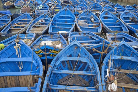 Small wooden fishing boats inside the historic harbour of Essaouira in Morocco.