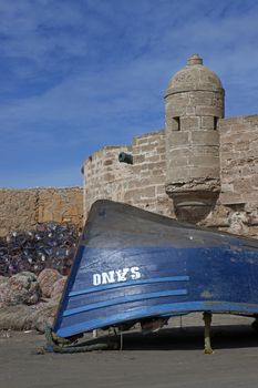 Small wooden fishing boat on the dockside inside the historic harbour of Essaouira in Morocco.