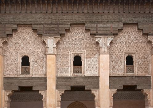 Ornate carving on the plastered walls and on the woodwork in the courtyard of the historic Ben Youssef Madrasa in the ancient heart of Marrakech in Morocco